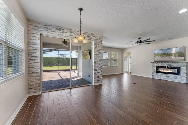 unfurnished living room featuring dark wood finished floors, arched walkways, visible vents, and ceiling fan