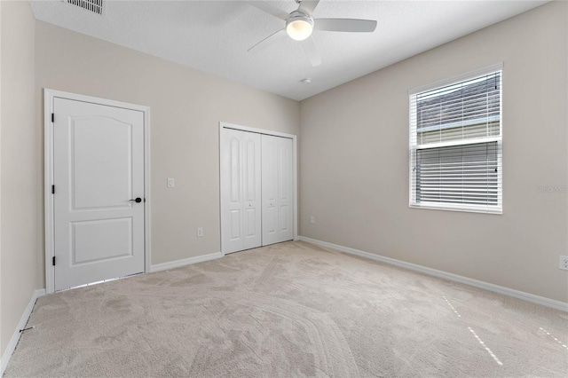 unfurnished bedroom featuring baseboards, a closet, carpet floors, and visible vents