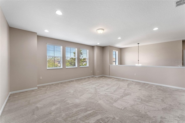 carpeted spare room featuring recessed lighting, baseboards, visible vents, and a textured ceiling