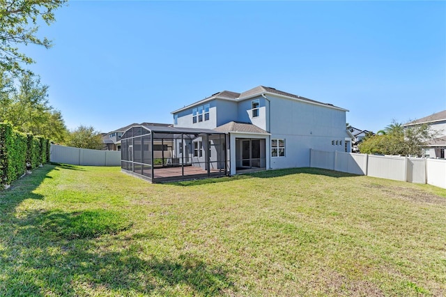 back of property featuring a yard, stucco siding, a lanai, and a fenced backyard