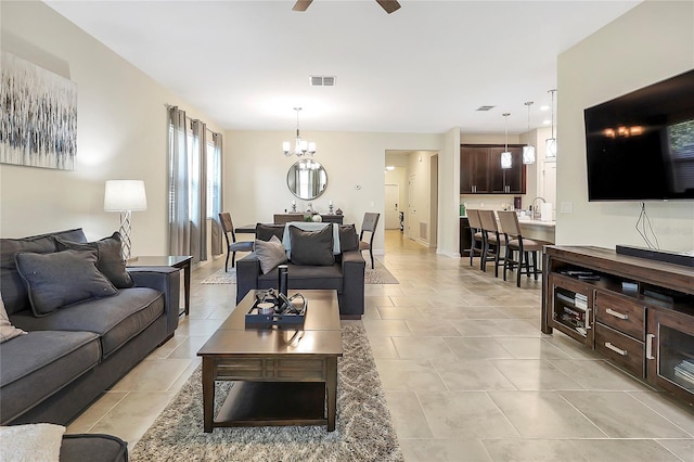 living room featuring ceiling fan with notable chandelier and light tile patterned floors