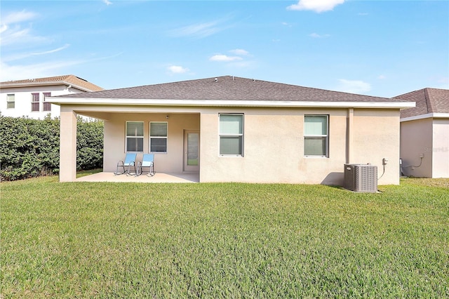 rear view of house with cooling unit, a yard, and a patio