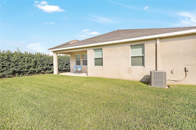 rear view of house featuring central AC, a patio area, and a lawn