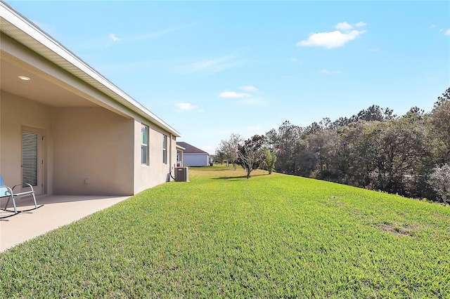 view of yard featuring central AC unit and a patio area