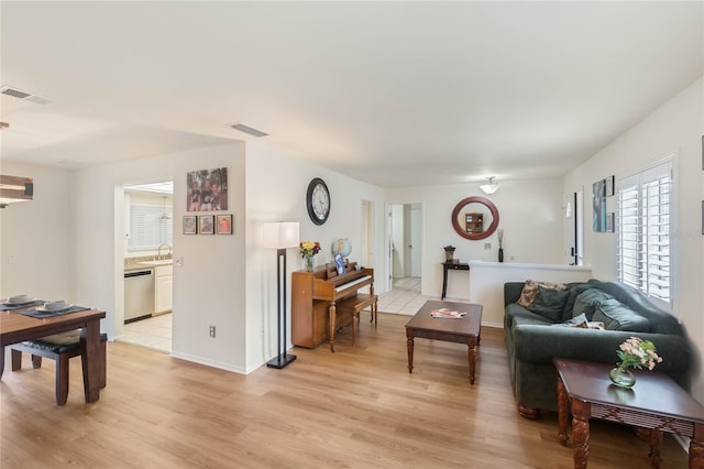 living room featuring sink and light hardwood / wood-style floors