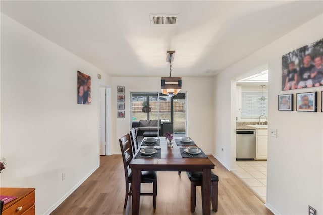 dining space featuring sink and light wood-type flooring