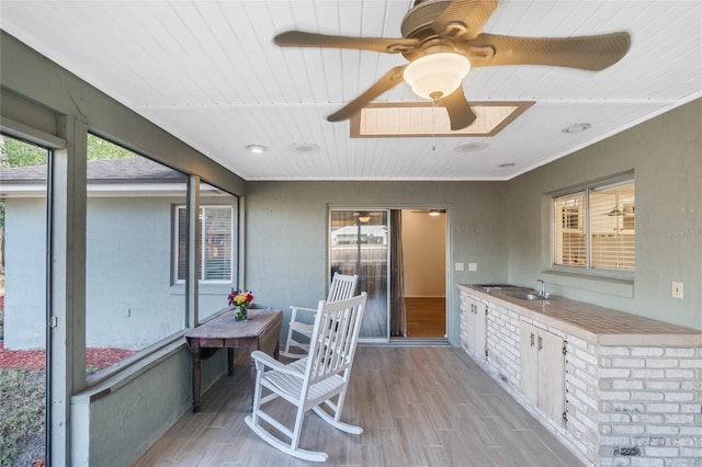 sunroom with sink, wooden ceiling, and ceiling fan