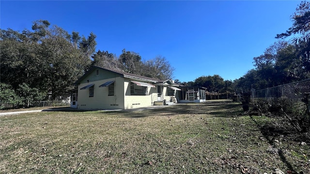 view of side of home featuring a yard and a sunroom