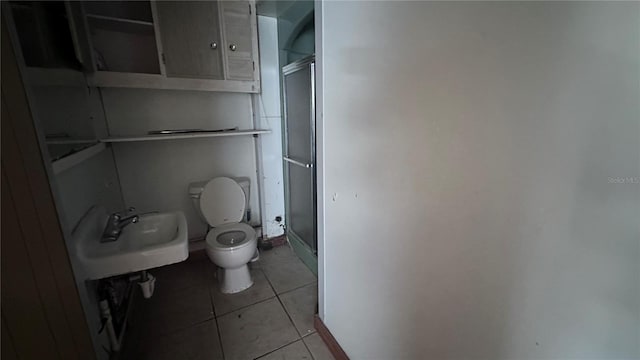 bathroom featuring an enclosed shower, sink, tile patterned flooring, and toilet