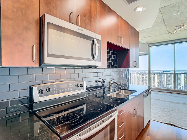 kitchen featuring stainless steel appliances, sink, hardwood / wood-style floors, and decorative backsplash