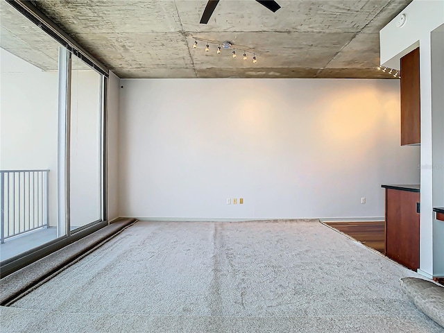 spare room with dark carpet and ceiling fan