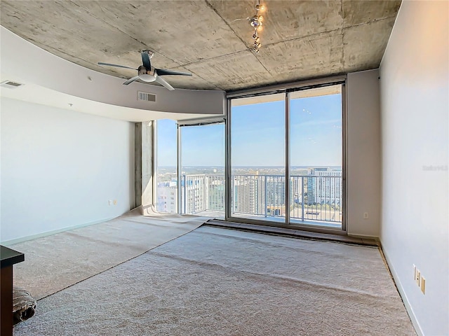 empty room featuring ceiling fan, floor to ceiling windows, and carpet floors