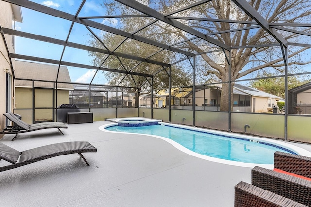 view of pool with an in ground hot tub, a patio, and glass enclosure