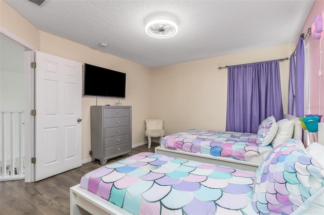 bedroom with wood-type flooring and a textured ceiling