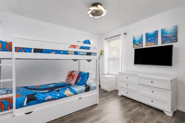 bedroom with a textured ceiling and dark hardwood / wood-style flooring