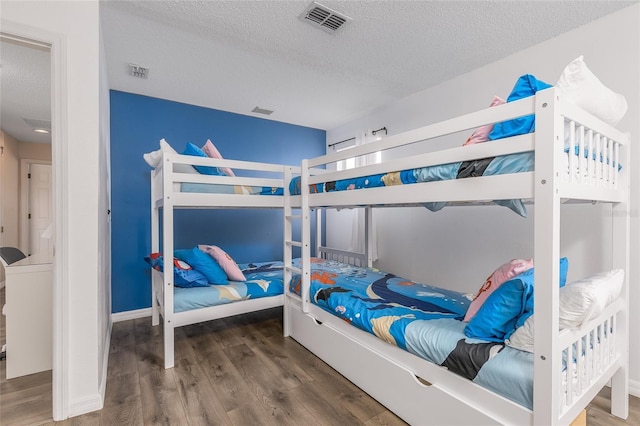 bedroom with wood-type flooring and a textured ceiling