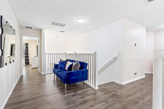 hall with dark wood-type flooring and a textured ceiling