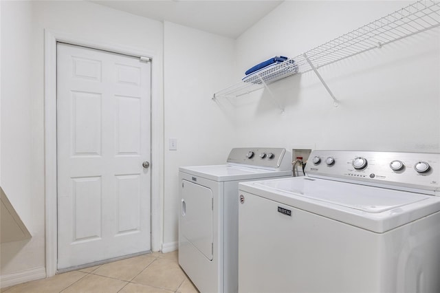 laundry room featuring separate washer and dryer and light tile patterned floors