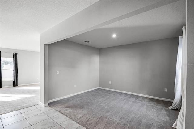 carpeted spare room featuring a textured ceiling