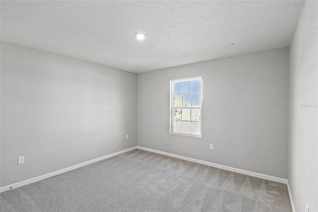 unfurnished room featuring carpet flooring and a textured ceiling