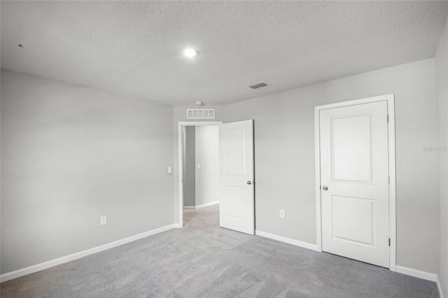 unfurnished bedroom with light carpet and a textured ceiling