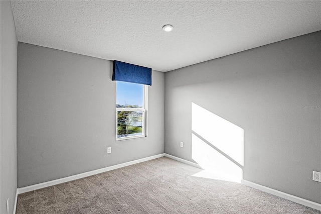 carpeted spare room with a textured ceiling