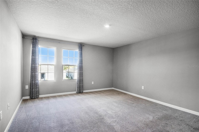 empty room featuring light carpet and a textured ceiling