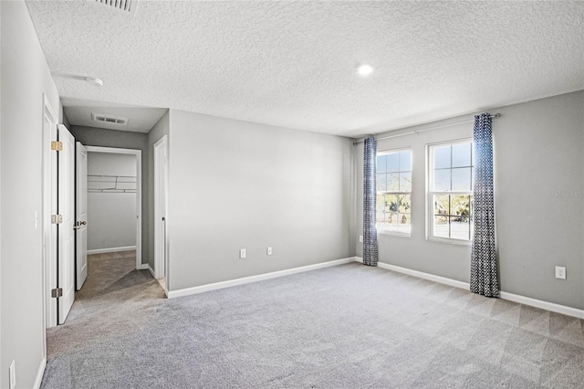 unfurnished bedroom featuring light colored carpet and a textured ceiling