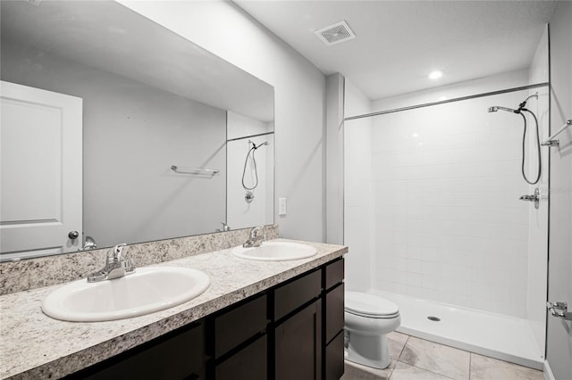 bathroom with vanity, toilet, and tiled shower