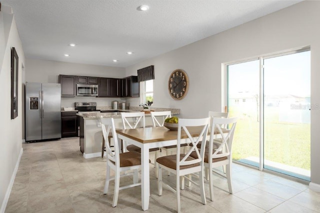 dining space with light tile patterned floors and a textured ceiling