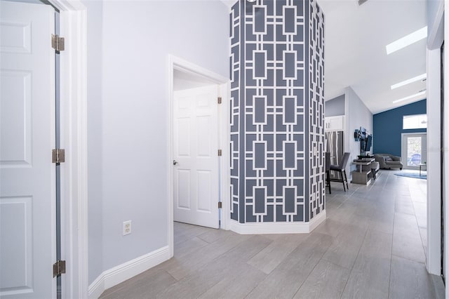 hallway featuring lofted ceiling and light hardwood / wood-style flooring