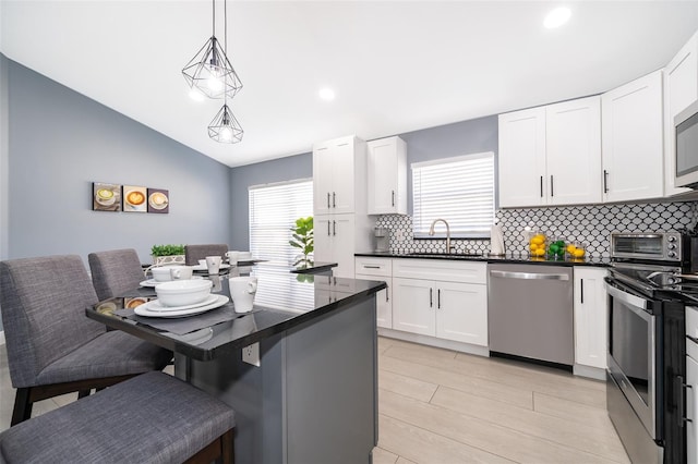 kitchen featuring white cabinetry, a breakfast bar, and appliances with stainless steel finishes