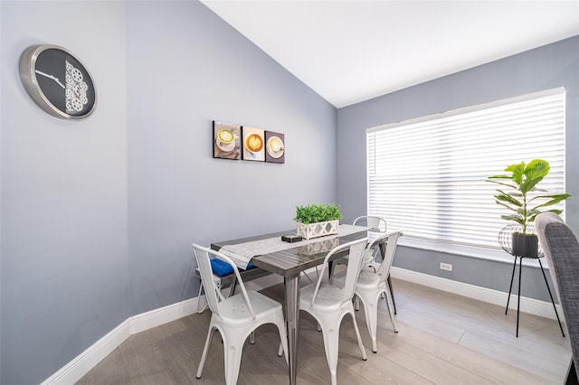 dining space featuring lofted ceiling and light wood-type flooring