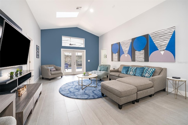 living room with hardwood / wood-style floors, lofted ceiling with skylight, and french doors