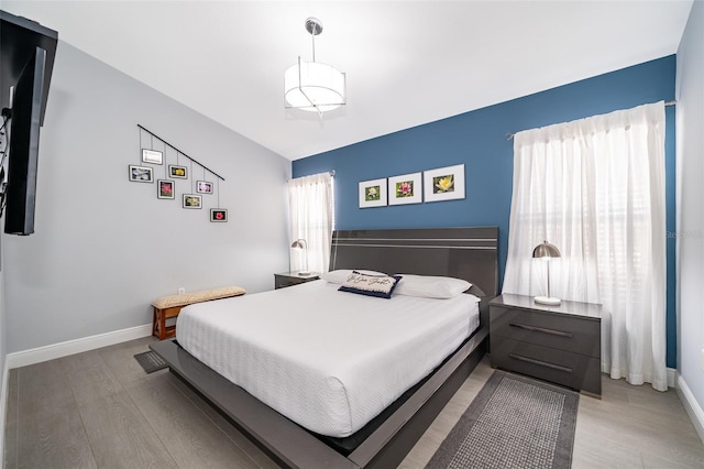 bedroom featuring multiple windows and light hardwood / wood-style flooring