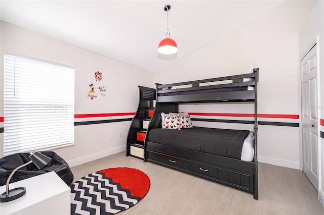 bedroom featuring lofted ceiling and light wood-type flooring