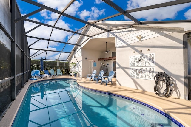 view of swimming pool featuring a patio area, ceiling fan, and glass enclosure