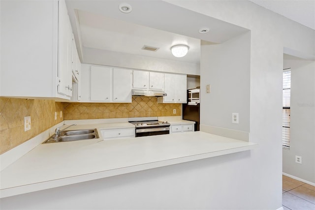 kitchen with electric range, visible vents, a sink, under cabinet range hood, and backsplash