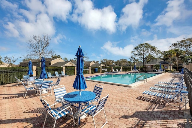 pool featuring fence and a patio