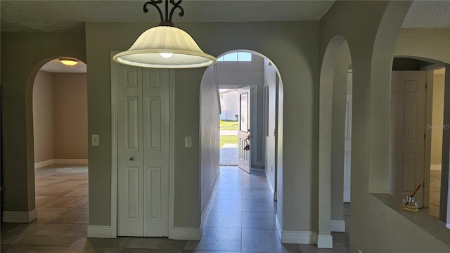 corridor featuring plenty of natural light and light tile patterned floors