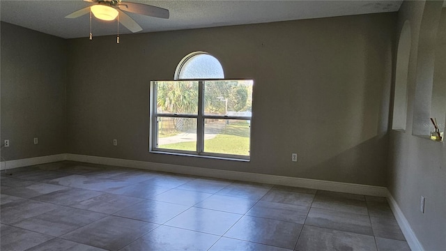 empty room with tile patterned floors and ceiling fan