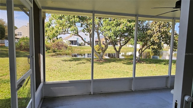 unfurnished sunroom featuring a water view and ceiling fan