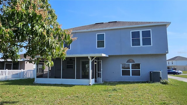 rear view of house with a sunroom, a lawn, and central air condition unit