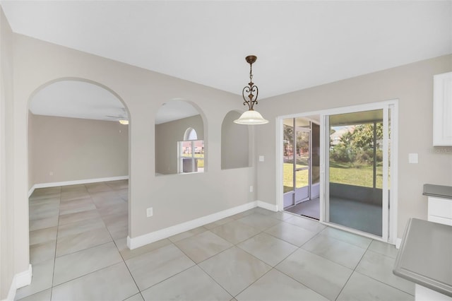 unfurnished dining area featuring ceiling fan and light tile patterned flooring