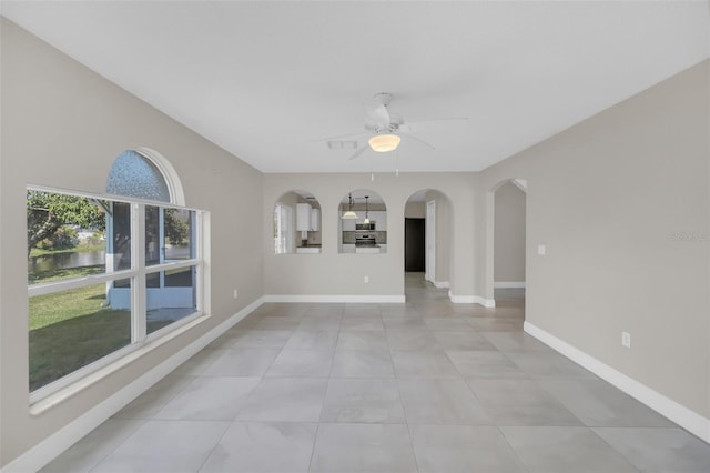 unfurnished living room featuring ceiling fan and light tile patterned floors