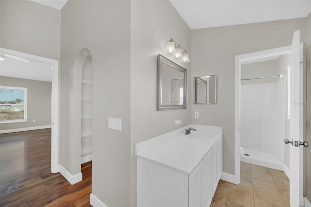 bathroom featuring vanity, a shower, and hardwood / wood-style floors