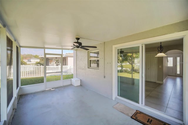 unfurnished sunroom featuring ceiling fan and a wealth of natural light