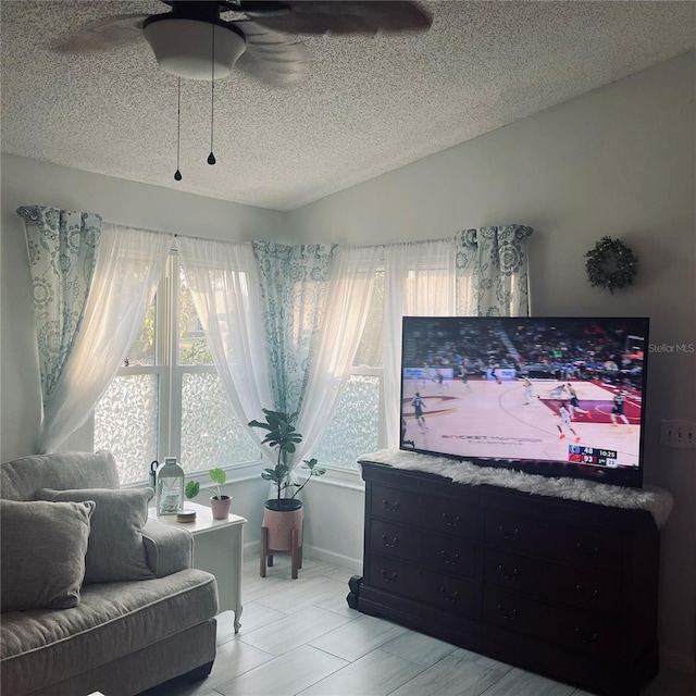 interior space with ceiling fan, lofted ceiling, and a textured ceiling