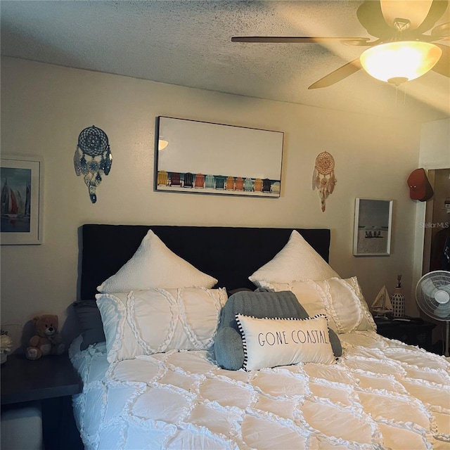 bedroom with ceiling fan and a textured ceiling