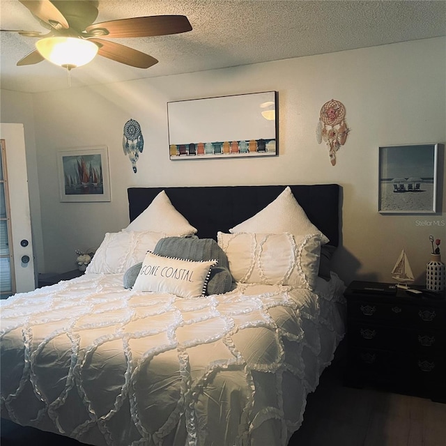 bedroom featuring ceiling fan, wood-type flooring, and a textured ceiling